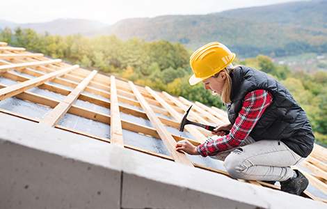artisan couvreur construisant une toiture neuve