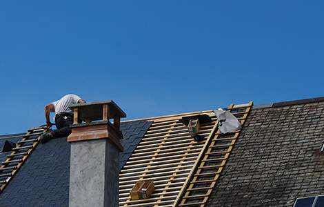 artian couvreur rénovant une toiture