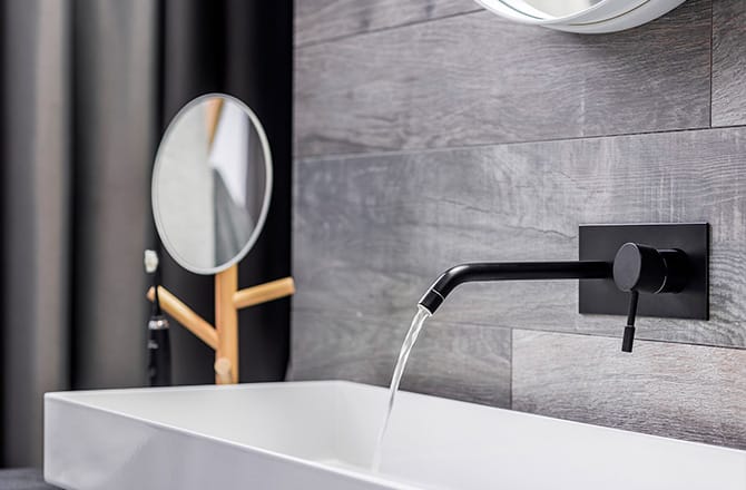 Une vasque blanche design et sa robinetterie noire