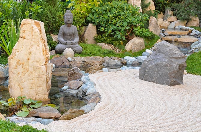 Une statue de Bouddha en pierre dans un jardin japonais