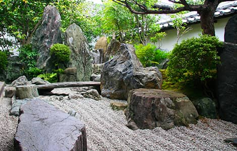 un banc en pierre dans un jardin zen