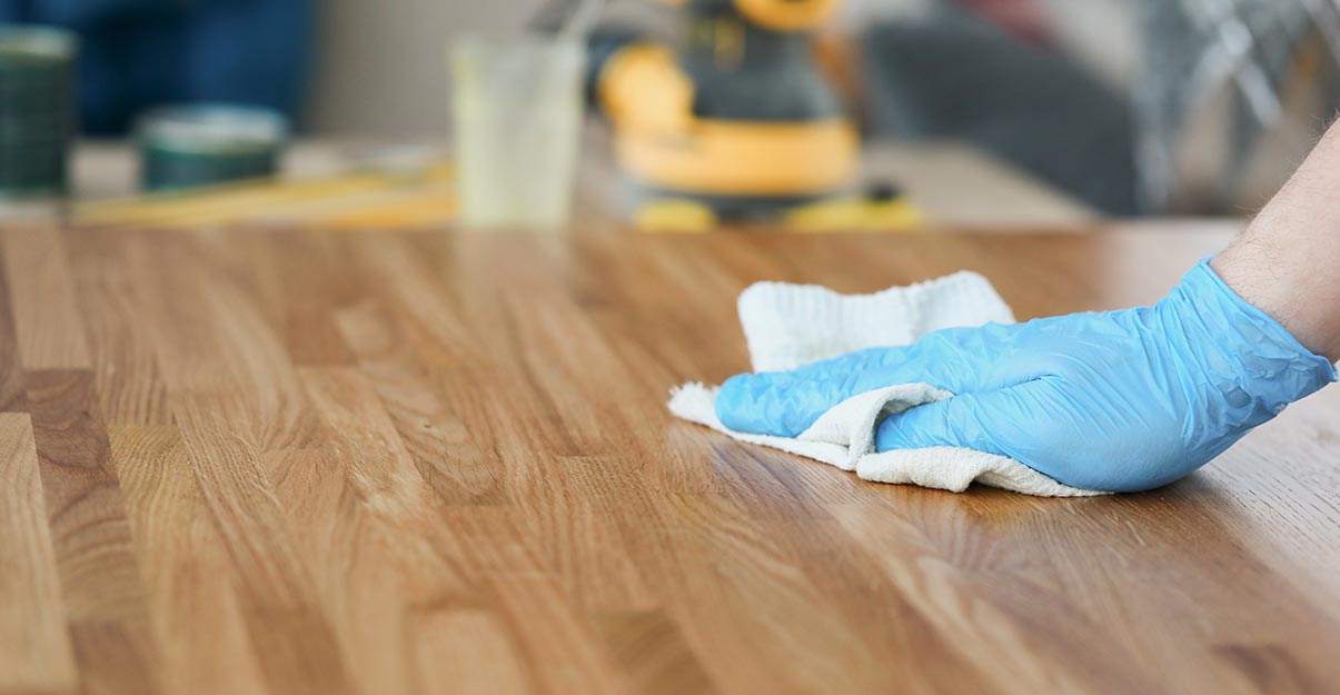 Nettoyage du bois avec un chiffon et des gants