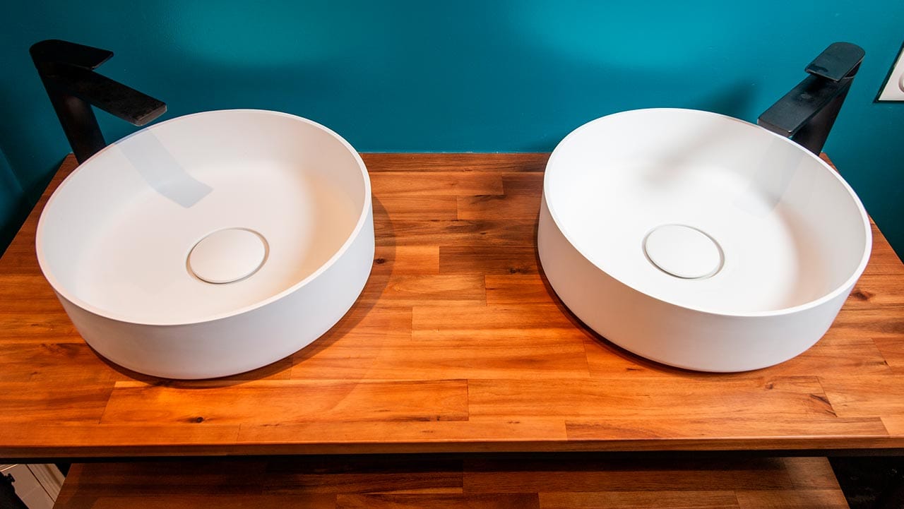 Deux vasques rondes et blanches qui contrastent avec les mitigeurs noirs aux formes rectilignes.