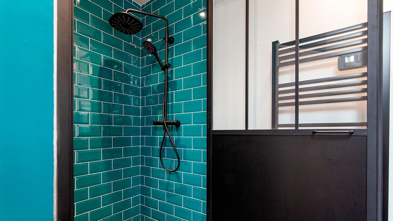 Une porte de douche battante type verrière qui apporte style et facilité d'accès à la douche.